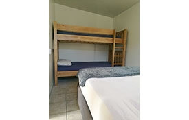a double bed and set of single bunks in the room